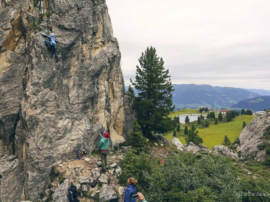 A climber on a sunlit rock face with an experienced guide.