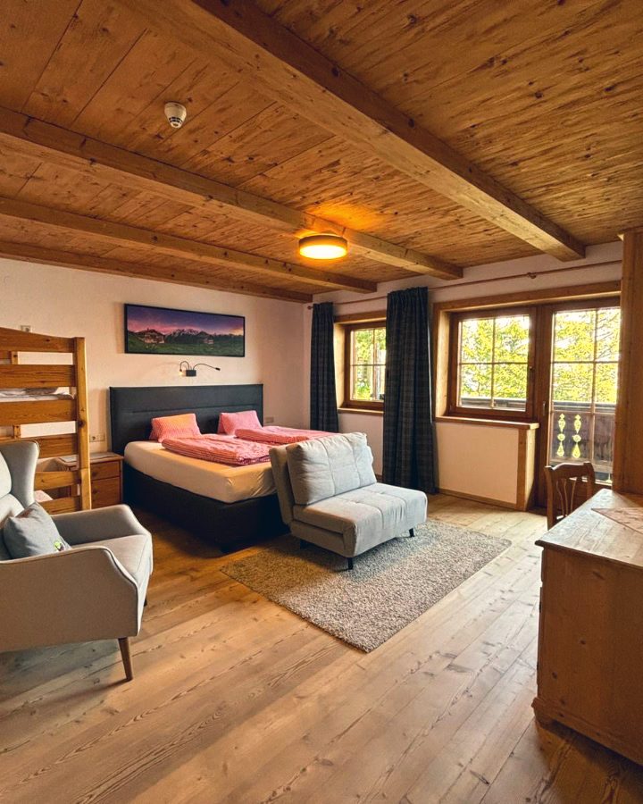 A bright deluxe double room in the lodge, warm timber and mountain light.