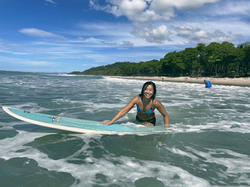 A surfer riding a turquoise wave on the Nicoya Peninsula.