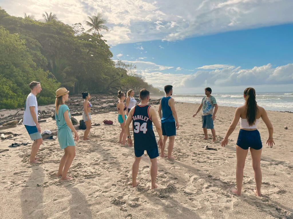 A group practising yoga on the beach at first light.