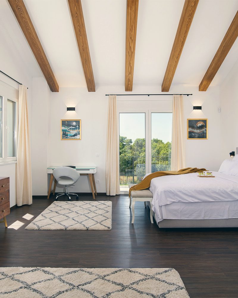 The villa's master bedroom, with a king-size bed and panoramic windows.