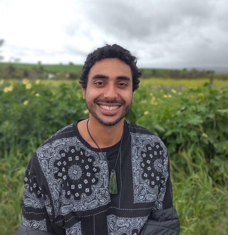 Gabriel, smiling in a green field.