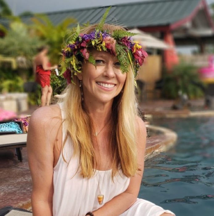Kerstin, smiling in a flower crown beside the water.