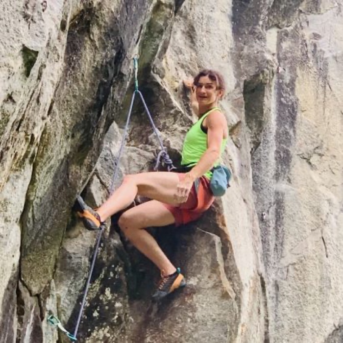 Kristina mid-climb on a granite rock face.